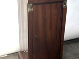 a small wooden cabinet with a black top on the floor