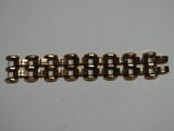 un gros plan d'un bracelet en or auquel est attachée une chaîne