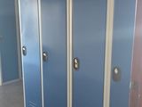 several blue lockers are lined up in a hallway of a building