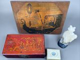 a small box with a painting on it next to a figurine and a small box with a painting on it