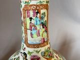 a vase with a painting on it sitting on a table