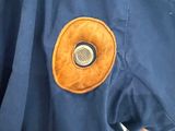 a blue jacket with a brown button on it