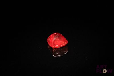 a red diamond on a black surface in the dark