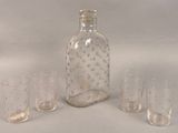quatre verres et une bouteille posés sur une table