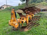 a close up of a tractor plow sitting in the grass