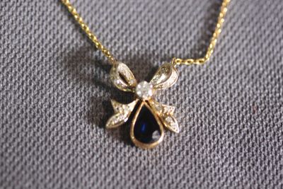 gold plated necklace with a tear shaped sapphire stone and a gold chain