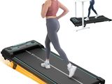 woman running on a treadmill with a laptop on a desk