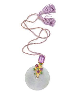 un gros plan d'un collier orné d'un pompon sur fond blanc