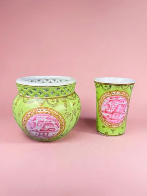deux vases verts ornés de motifs roses sur fond rose