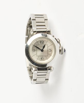 un gros plan d'une montre sur une surface blanche avec un fond blanc