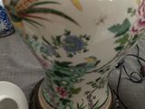 a large vase sitting on top of a table next to a cup