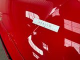 a close up of a red car with a sign on it