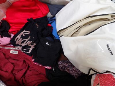 un sac blanc rempli de vêtements et une paire de chaussures rouges