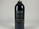 a bottle of red wine sitting on top of a white table