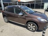the brown car is parked in front of a building in a parking lot
