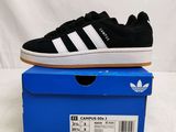 a pair of black and white sneakers on top of a blue box