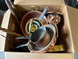 une boîte remplie de casseroles et de poêles posée sur une table