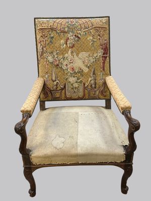 an old chair with a tapestry on the back of it