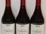 trois bouteilles de vin sont alignées sur une table