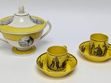 three pieces of yellow and white porcelain tea set on a white surface