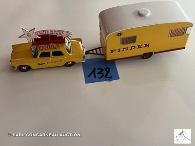 un camion miniature tirant une remorque sur laquelle est accrochée une pancarte