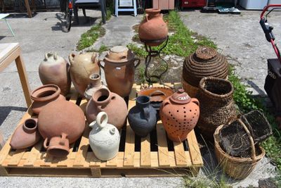 many vases sitting on a pallet in the yard