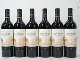 six bouteilles de vin rouge sont alignées sur une table