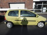 a small yellow car that is parked in a parking lot