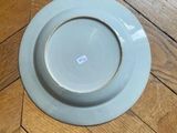 a white plate sitting on a wooden floor next to a wooden floor