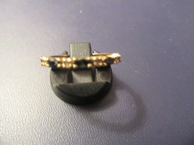 une bague en or posée sur un bouton noir