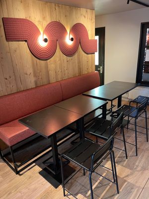 tables and chairs in a restaurant with a wood paneled wall behind them