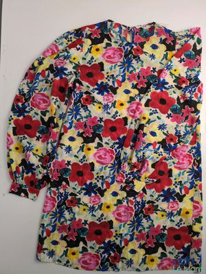 une chemise à fleurs jaune et rouge, avec un imprimé floral noir et blanc