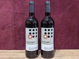 two bottles of wine sitting on top of a wooden table