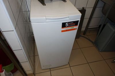 un petit réfrigérateur blanc dans le coin d'une cuisine