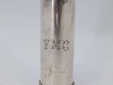 an old silver cup with a handle on a white background