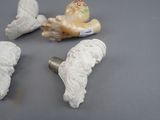four white ceramic angel figurines sitting on top of a table