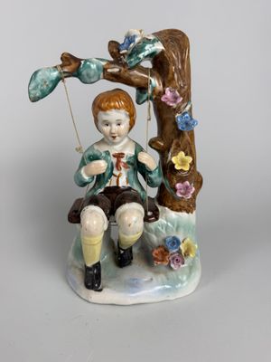 Sujet en porcelaine émaillée polychrome figurant un enfant s…