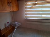 a fan in the corner of a room next to a window