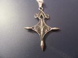 l'image d'une croix argentée posée sur une surface noire