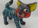 une figurine représentant un chat posée sur une surface blanche