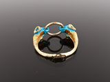 an image of a gold and turquoise ring on a black surface