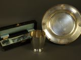 a silver plate and a silver cup next to a box