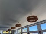 many lamps hanging from the ceiling in this room