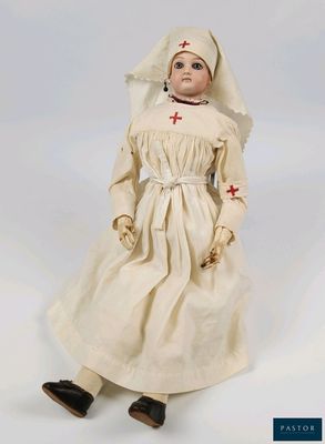 une image représentant une poupée en forme de religieuse, vêtue d'une robe blanche ornée d'une croix rouge