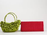 un sac à main vert et rouge à côté d'un porte-monnaie rouge sur fond blanc