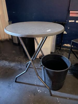 a small table with a bucket on it in a room