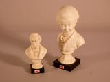 deux statues représentant un garçon et un buste de garçon