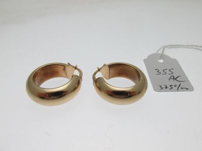 une paire de boucles d'oreilles en or sur fond blanc