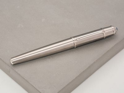 a silver pen sitting on top of a piece of paper