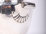 a silver tea pot with a bird on it